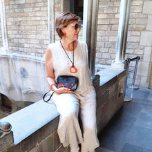 Older woman holding a black leather fanny pack/small bag